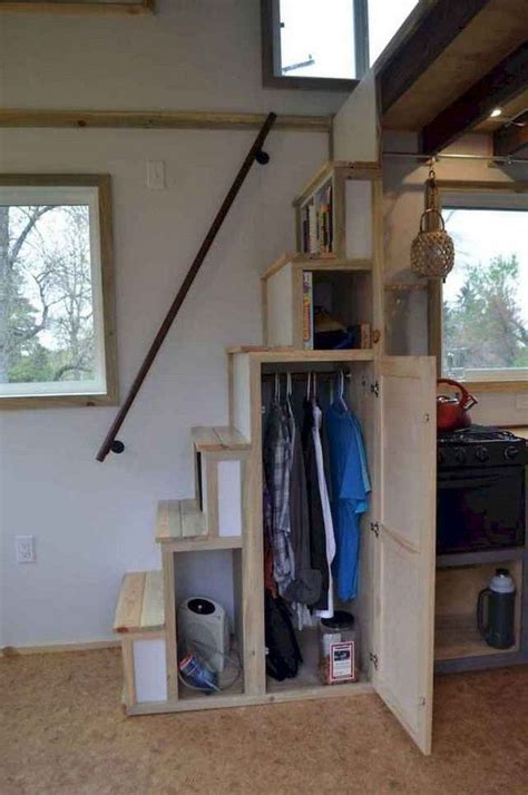 An Open Storage Unit With Clothes Hanging On The Wall And Stairs