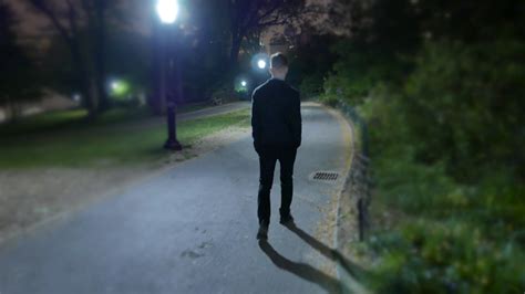 One Man Walking Alone Trough City Park At Night Spooky Scary