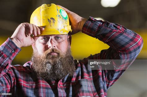 Bearded Construction Worker Putting On Hardhat High Res Stock Photo