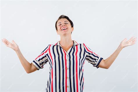 free photo mature woman in striped blouse showing helpless gesture and looking cheerful