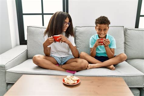 brother and sister having breakfast sitting on sofa at home stock image image of enjoy