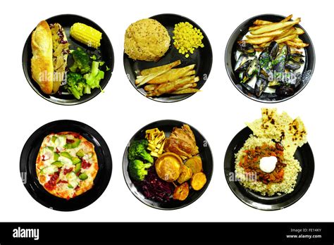 Different Meals On Black Plates Photographed Against A White Background
