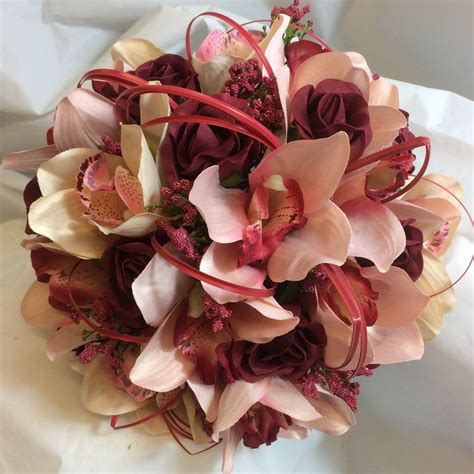 A Brides Bouquet Of Coral And Burgundy Artificial Roses And Orchids