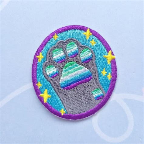 A Purple And Blue Patch With A Paw Print On The Bottom That Has Stars Around It