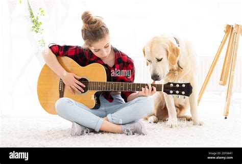 Teenage Girl Playing Guitar With Cute Dog At Home Stock Photo Alamy