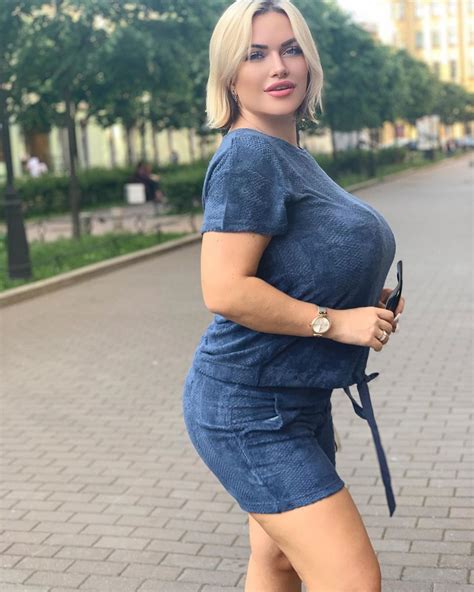 A Woman Is Posing For The Camera In A Blue Dress