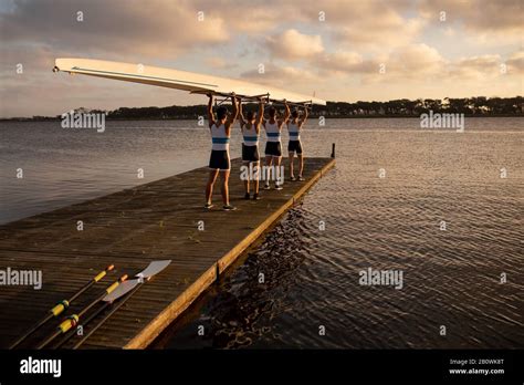 Teammates Carrying The Rowing Boat Together Stock Photo Alamy