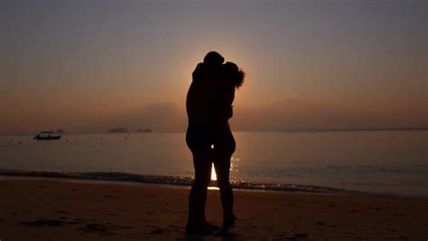 silhouette of happy couple embracing on beach at sunset slow motion hd 1920x1080 stock