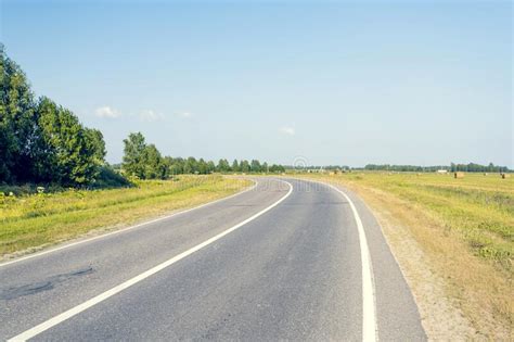 Asphalt Road Leading Into The Distance Around The Bend Stock Image