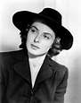 an old black and white photo of a woman wearing a hat