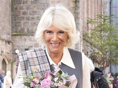 An Older Woman Is Smiling And Holding Flowers In Her Hand While Walking