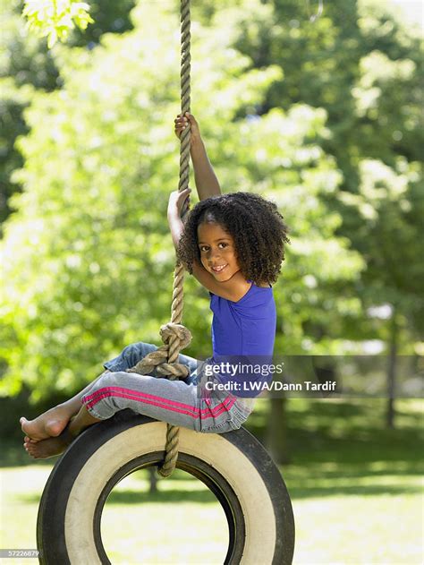 Portrait Of Girl On Tire Swing High Res Stock Photo Getty Images