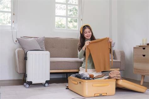 premium photo beautiful asian woman pack things or clothes into a suitcase preparation for a