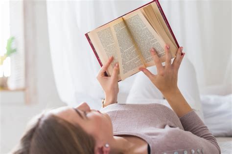 Gros plan de jeune femme lit lit lecture livre Télécharger des