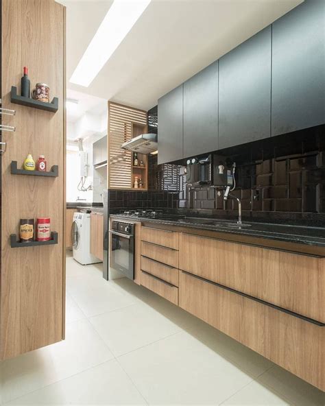 Cozinha integrada com a área de serviço na madeira e preto com tijolinho Projeto Renata