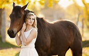 Pretty blonde girl and a brown horse