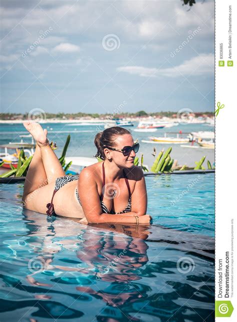 Portrait Of Beautiful Tanned Woman In Black Swimwear Relaxing In