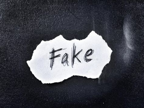 On Dark Background The Word Fake Written In Rough Style Stock Photo