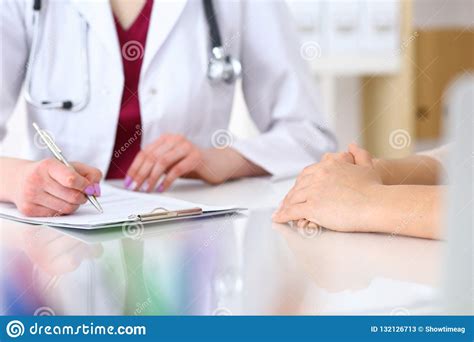 Doctor Woman Consulting Patient While Filling Up An Application Form At