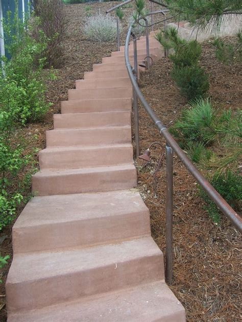 While keeping one rail post on the step (⇓), raise the other rail post off the mounting surface (⇑) until the level reads plumb. The 2 Minute Gardener: Photo - Concrete Stairs with Copper ...