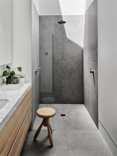 Bathroom with navy and white geometric tiles paired with marble vanity. Large format gray concrete look tile in curbless walk in ...