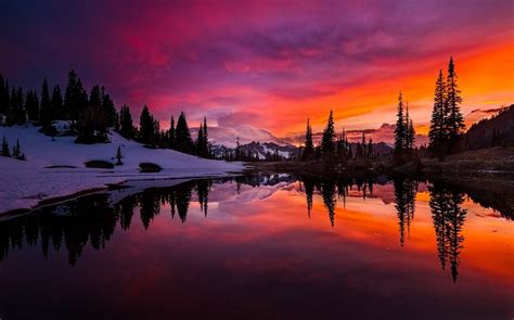 Three Beside Calm Body Water Across Snow Covered Mountain