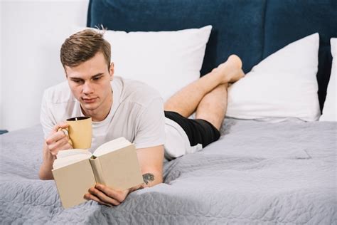 Free Photo Man Reading Book Lying On Bed