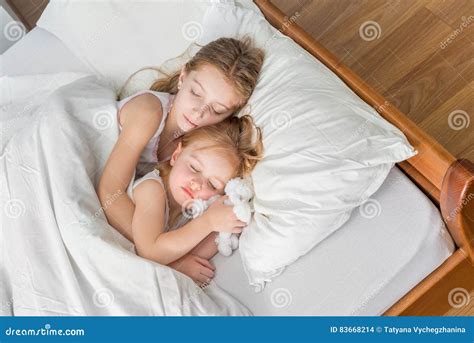 Two Little Sisters Hugging In Bed Stock Photo Image Of Cute Laugh