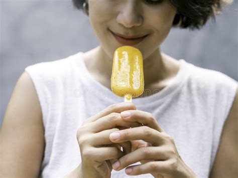 Yellow Popsicle In Happy Smiling Beautiful Asian Woman`s Hand Stock
