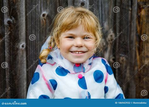 Outdoor Portrait Of Happy Smiling Little Toddler Girl Wearing Rain