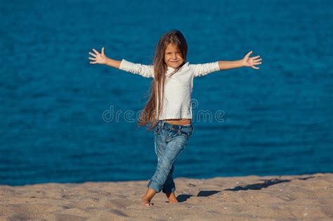 Прелестная счастливая усмехаясь маленькая девочка на пляже Стоковое Изображение изображение
