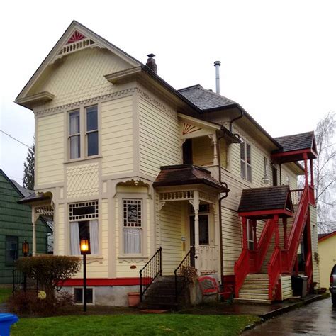 A White House With A Red Staircase Next To It And A Blue Fire Hydrant