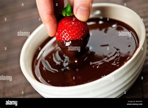 Hand Dipping Fresh Strawberry In Melted Chocolate Stock Photo Alamy
