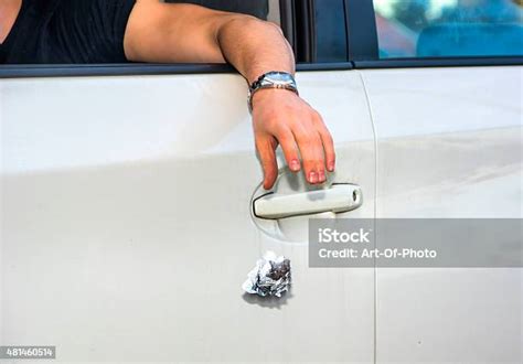 Man Tossing Litter From Open Car Window Stock Photo Download Image