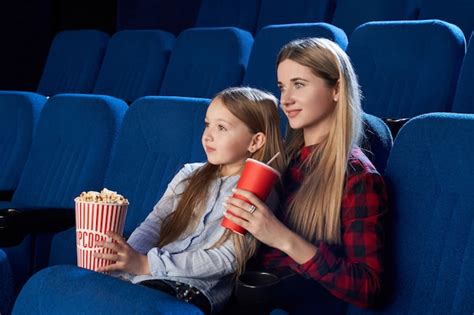 Madre E Hija Disfrutando De La Película En El Cine Foto Gratis