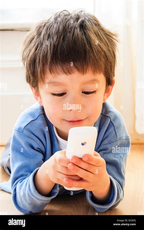 Caucasian Child Boy 6 7 Year Old Indoors Holding A Telephone In Hand