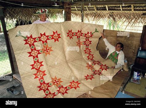 two local women showing a hand made pandan mat in the women handicraft centre on rarotonga