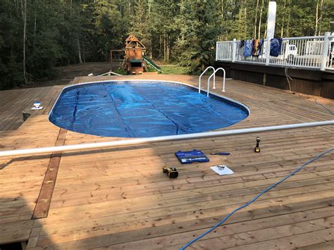 Half of the pool is buried in the ground, with the other half exposed. Semi Inground Pools | Pool Supplies Canada