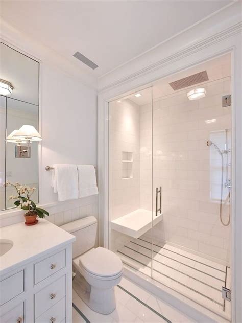 A White Bathroom With A Toilet Sink And Shower Stall In The Middle Of It