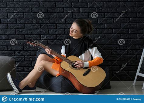 Beautiful Woman Playing Guitar Near Dark Brick Wall Stock Photo Image