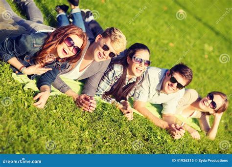 Groep Die Studenten Of Tieners In Park Liggen Stock Afbeelding Image
