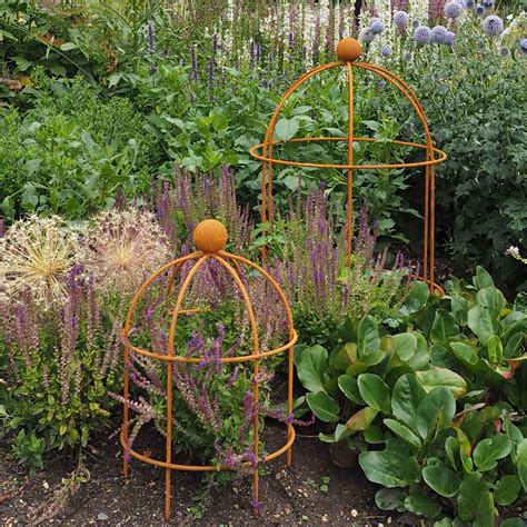 Made of raw metal, a barrington spiral plant support has a decorative steel ball on its tip. Lobster Pot Plant Support - Rust - Harrod Horticultural