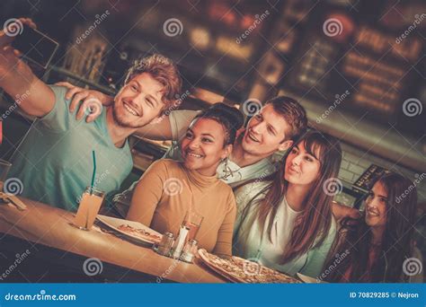 Cheerful Multiracial Friends Having Fun Eating In Pizzeria Stock Image