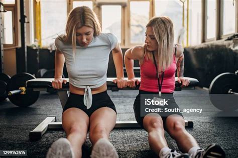 Female Personal Trainer And Her Female Trainee Exercise Together Stock