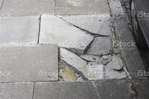 Broken Pavement Damage Cracked Paving Stones Next To Kerb Stock Photo