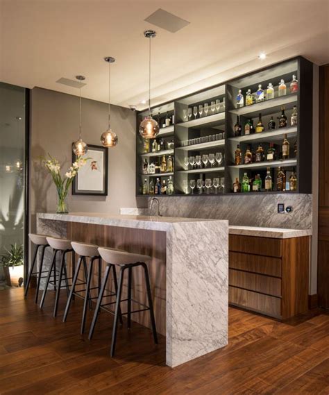 A Bar With Marble Counter Tops And Stools In Front Of Shelves Filled