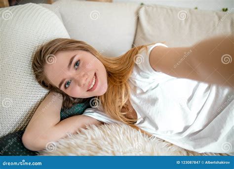 Happy Ginger Girl Taking A Selfie While Resting On The Bed Stock Image