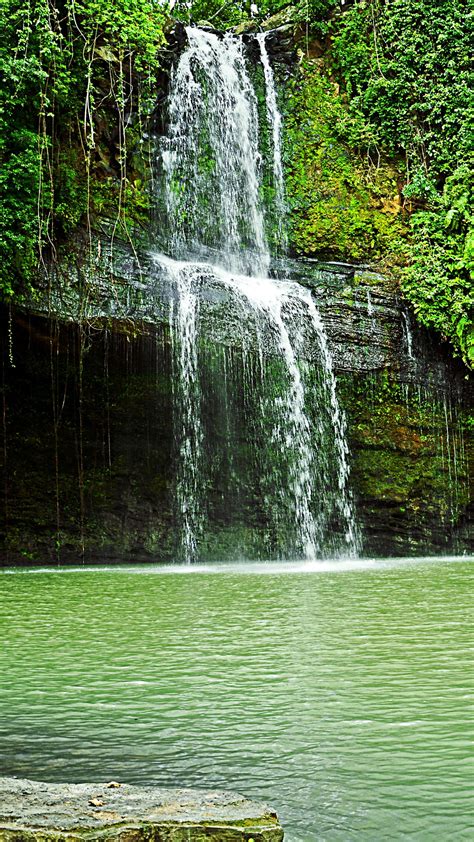 Landscape View Of Waterfalls On Rocks Pouring On Lake Green Trees
