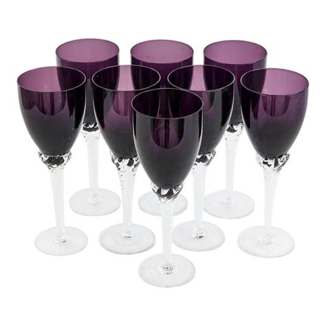 Six Purple Wine Glasses Are Lined Up In A Row On A White Surface One Is Empty