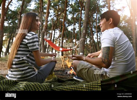 Happy Couple Roasting Marshmallows On Fire At Camp Stock Photo Alamy